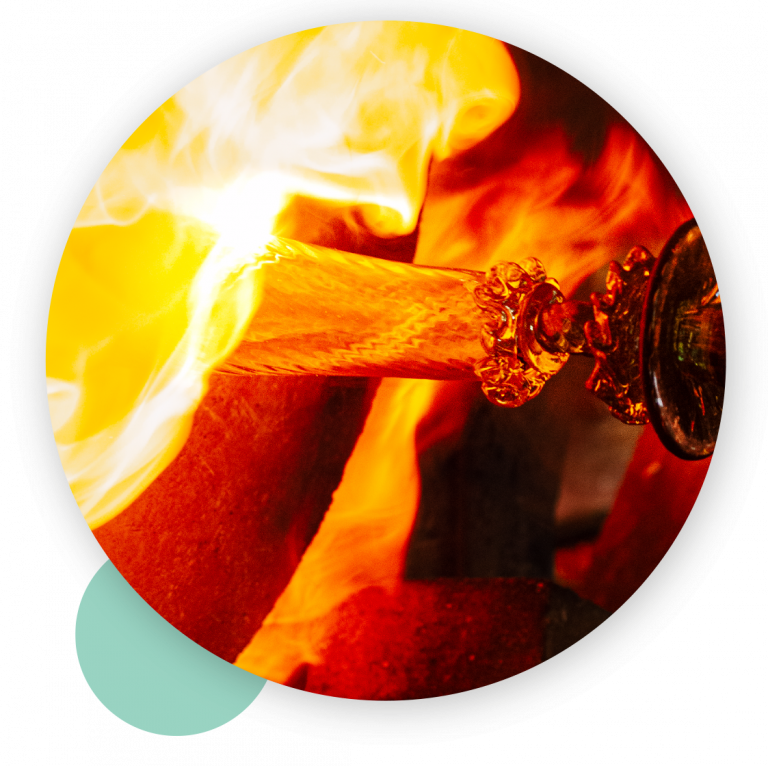 Proceso de fabricación de la copa Soraya. Gordiola. Se ve vidrio al rojo junto con fuego y se notan los detalles labrados de parte de la copa de vidrio.